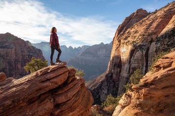 Adventurous Girl at the edge of a cliff is looking at a beautiful landscape view in the Canyon...