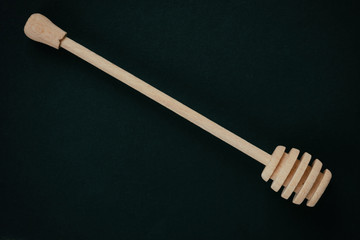 Wooden spoon of sweet natural honey. On black rustic table.