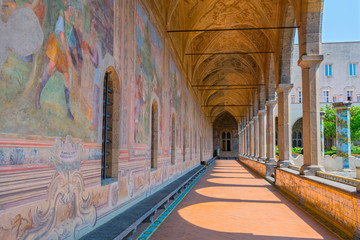 Alte Gemälde schmücken die Kreuzgangwände des Klosters Santa Chiara in Neapel, Italien.