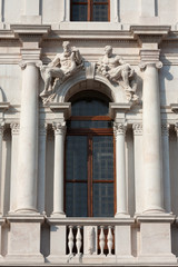 Window with statues on the top. Upper town of Bergamo, Italy