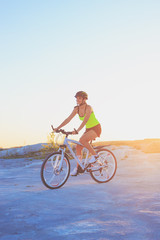 Fototapeta na wymiar Young beautiful woman with a sport bike, soft focus background