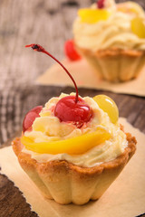 Small fruitcake with cream filling and cherry  for Christmas dinner.