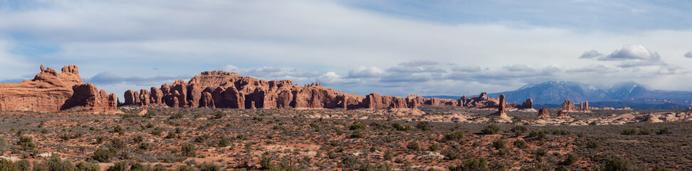 Fototapeta na wymiar Panoramic Landscape view of beautiful red rock canyon formations during a vibrant sunny day. Taken in Arches National Park, located near Moab, Utah, United States.