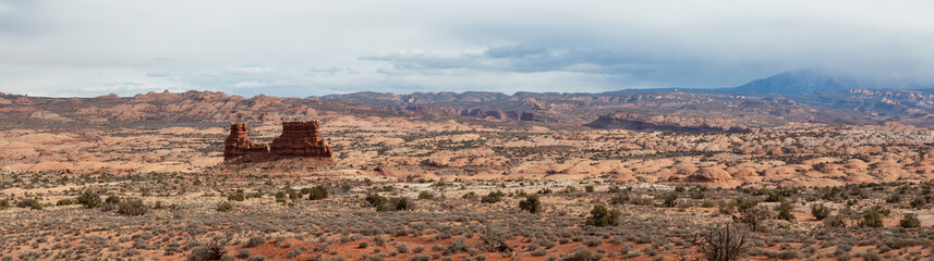 Panoramic landscape view of beautiful red rock canyon formations during a vibrant sunny day. Taken in Arches National Park, located near Moab, Utah, United States.