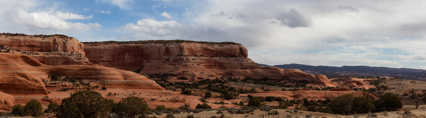 Panoramic view sandstone mountains in a desert during a vibrant sunny day. Located near Monticello, Utah, United States.