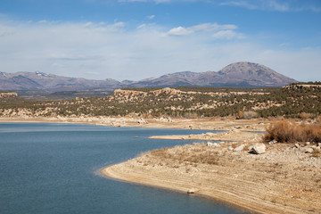 Panoramic view of a lake, Recapture Reservoir, in a desert during a vibrant sunny day. Located near Blanding, Utah, United States.