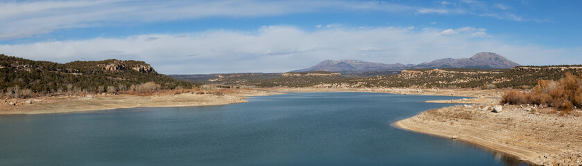 Fototapeta na wymiar Panoramic view of a lake, Recapture Reservoir, in a desert during a vibrant sunny day. Located near Blanding, Utah, United States.