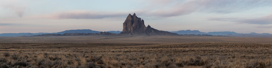 Dramatic panoramic landscape view of a dry desert with a mountain peak in the background during a...