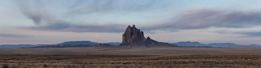 Fotobehang Chocoladebruin Dramatische panoramische landschapsmening van een droge woestijn met een bergtop op de achtergrond tijdens een levendige bewolkte zonsopgang. Genomen op Shiprock, New Mexico, Verenigde Staten.  © edb3_16