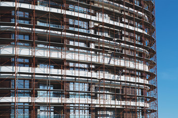 Fototapeta na wymiar Constructed buildings of a large residential complex against a blue sky. Modern buildings under construction. The texture of the facade of the building
