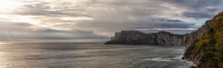 Striking panoramic landscape of a rocky coastline during a cloudy sunrise. Taken in Forillon National Park, near Gaspé, Quebec, Canada.