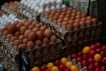 Chicken eggs with while eggshell in a cardboard packaging. Heap of chicken eggs from village. Tasty breakfast. Eggs on the counter. Broken egg.