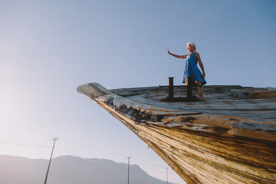 Little girl playing on an old wooden boat