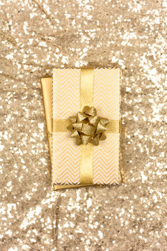 Golden themed handmade Christmas gift on golden sequin background
