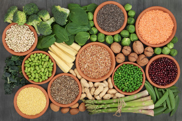 High protein source health food with fresh vegetables, legumes, nuts, grains and seeds, high in dietary fibre, antioxidants, anthocaynins and vitamins. Top view on rustic wood background.