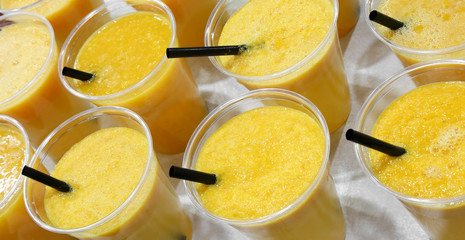healthy orange juice in plastic cups