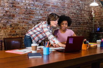 Business women working at laptop in conference table