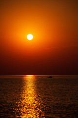 dramatic red orange colored sunset over the calm sea at summer