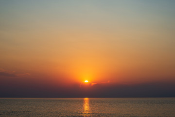 dramatic red orange colored sunset over the calm sea at summer