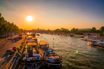 Fototapeta premium Sunset view on bridge and buildings on the Seine river in Paris, France
