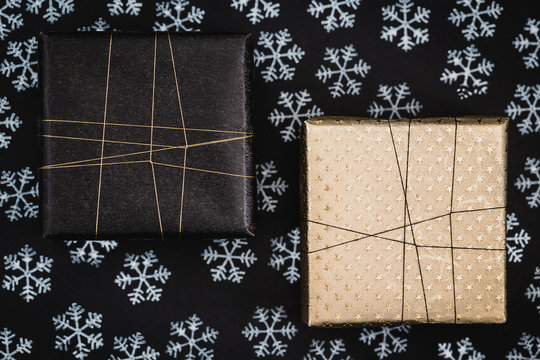 Two gifts on black background with snow stamps