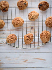 Appetizing and tasty oatmeal cookies with raisins and milk on a bright table.