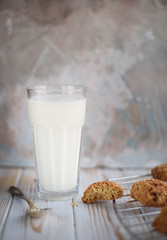 Appetizing and tasty oatmeal cookies with raisins and milk on a bright table.
