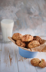 Appetizing and tasty oatmeal cookies with raisins and milk on a bright table.