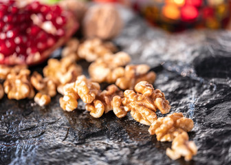  Nuts, pomegranates with seeds on the natural black stone