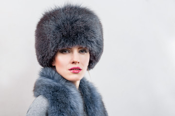 Beautiful girl in a fur lush hat