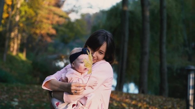 mom holds a beautiful baby in her arms, the baby has a bandage on her head, mom holds a piece in her hands and shows the child