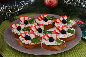 Festive sandwiches with crab sticks, feta cheese and black olives. Christmas background
