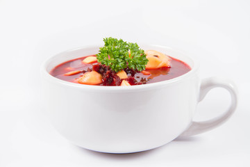 Traditional polish Christmas Eve dish: red borscht with uszka a mushroom filled kind of dumpling decorated with parsley 