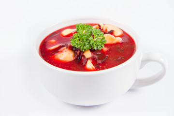 Traditional polish Christmas Eve dish: red borscht with uszka a mushroom filled kind of dumpling decorated with parsley 