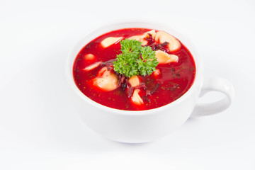 Traditional polish Christmas Eve dish: red borscht with uszka a mushroom filled kind of dumpling decorated with parsley 