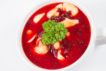 Traditional polish Christmas Eve dish: red borscht with uszka a mushroom filled kind of dumpling decorated with parsley 