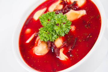 Traditional polish Christmas Eve dish: red borscht with uszka a mushroom filled kind of dumpling decorated with parsley 