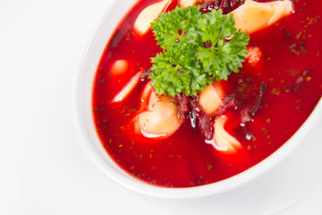 Traditional polish Christmas Eve dish: red borscht with uszka a mushroom filled kind of dumpling decorated with parsley 