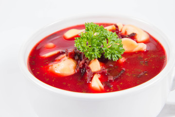 Traditional polish Christmas Eve dish: red borscht with uszka a mushroom filled kind of dumpling decorated with parsley 