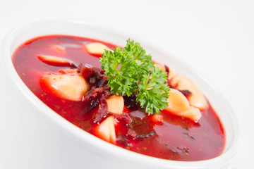 Traditional polish Christmas Eve dish: red borscht with uszka a mushroom filled kind of dumpling decorated with parsley 