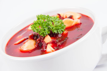 Traditional polish Christmas Eve dish: red borscht with uszka a mushroom filled kind of dumpling decorated with parsley 