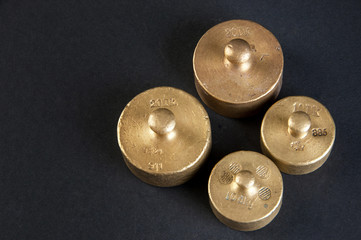 Vintage bronze weights on black background.