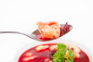 Traditional polish Christmas Eve dish: red borscht with uszka (a mushroom filled kind of dumpling) decorated with parsley eaten with a spoon