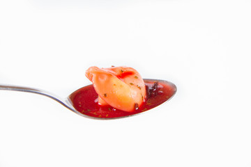 Traditional polish Christmas Eve dish: red borscht with uszko (a mushroom filled kind of dumpling) on a spoon