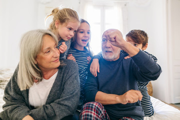 Grandpa doing magic trick to their grandchild at home.