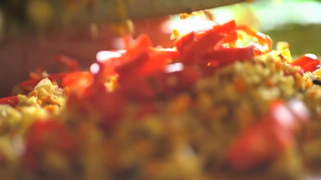 Asian chef preparing Basa gede chopping traditional spices on wooden cutting board in Balinese kitchen