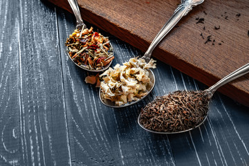 Various types of dry tea leaves and jasmine. The composition of tea with different types of tea from different herbs. Tea leaves and jasmine flowers on wooden background.