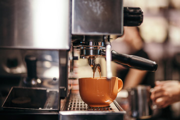 Machine brewing coffee in cup