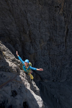 Young female alpinist rock climbing in the Dolomites, Italy