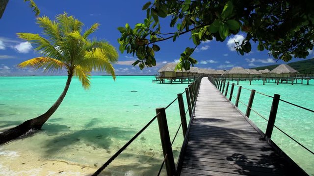 Overwater boardwalk luxury Bungalows in tropical Aquamarine lagoon beach vacation resort of Bora Bora South Pacific French Polynesia